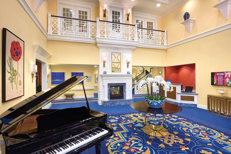A luxurious hotel lobby featuring a grand piano, elegant decor, and a cozy fireplace.