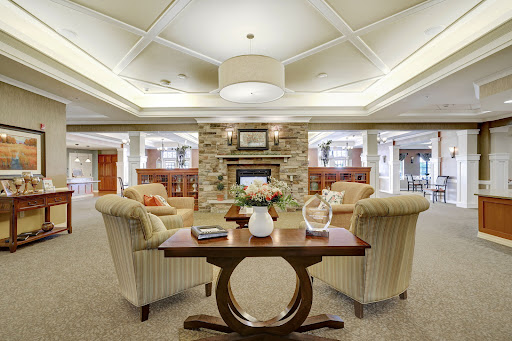 A cozy and modern lounge area featuring comfortable seating and a warm fireplace.