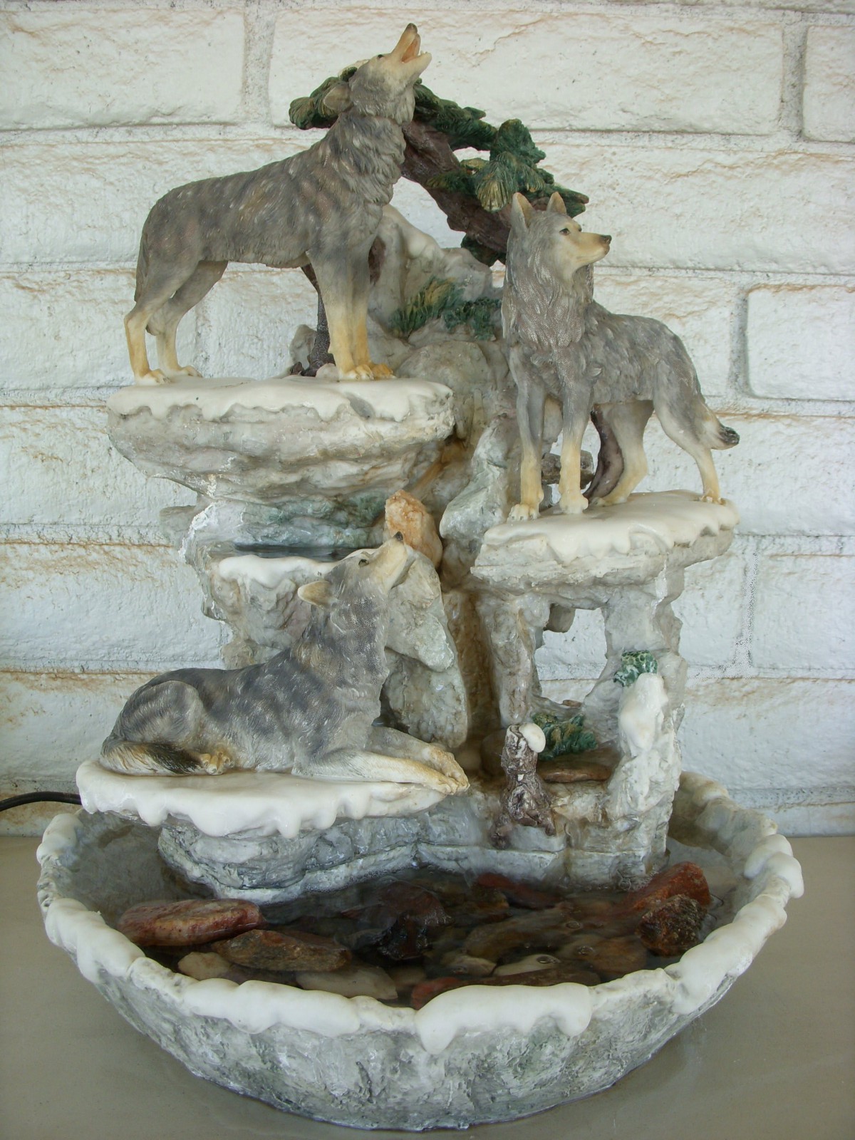 A decorative wolf-themed fountain with multiple wolves on a rocky landscape.