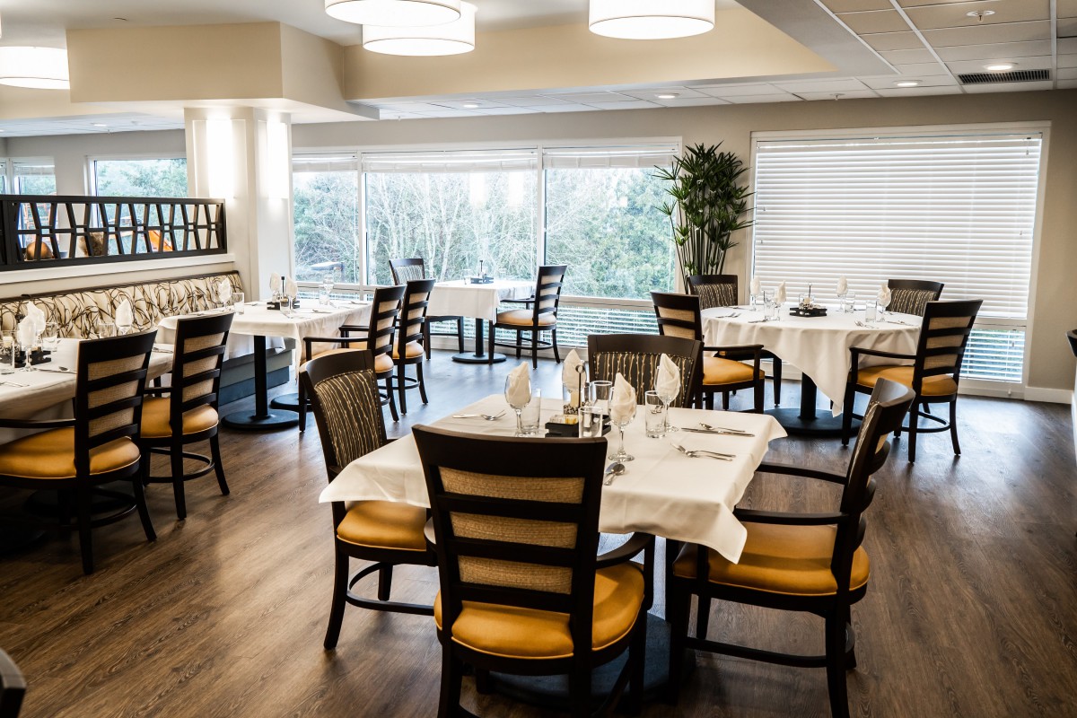 A well-lit restaurant dining room with neatly arranged tables and chairs.