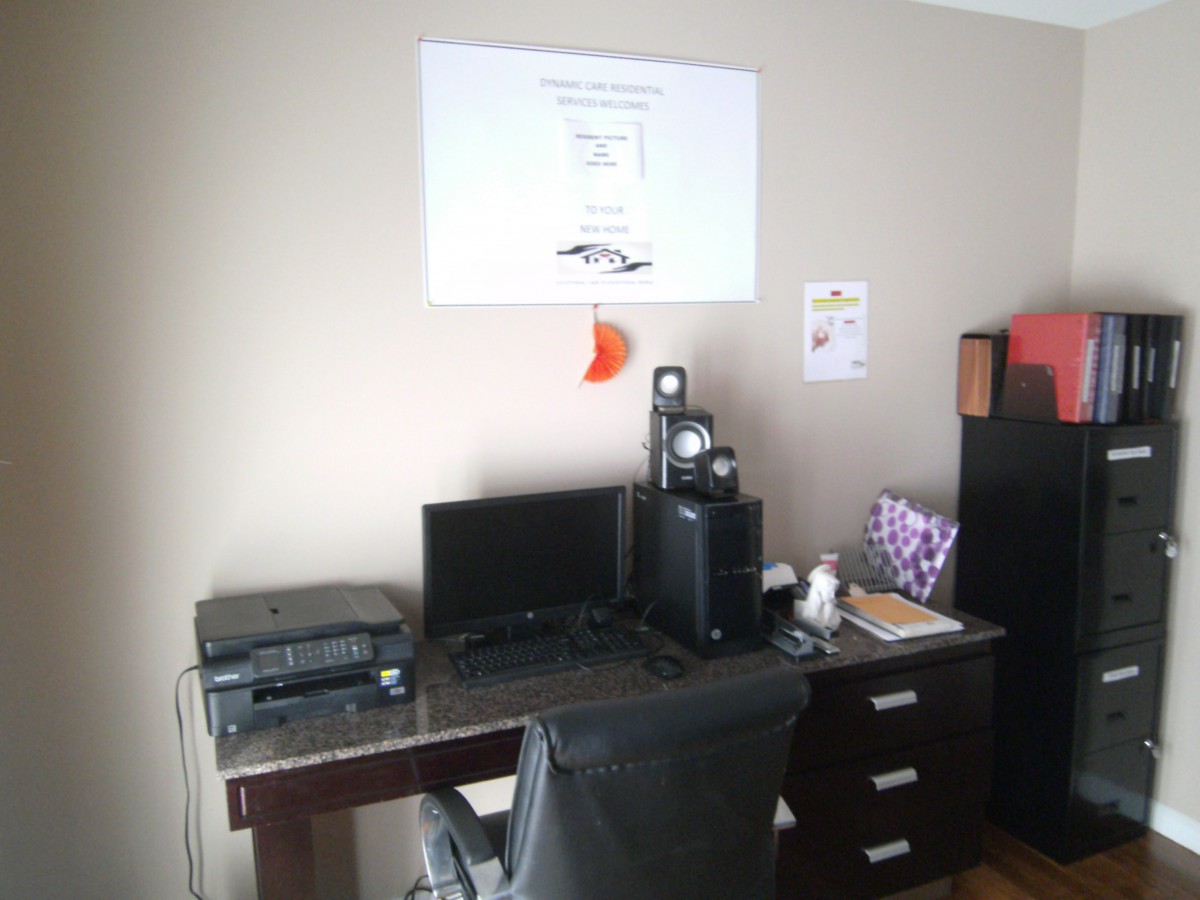 A neatly organized home office setup with a computer desk and equipment.
