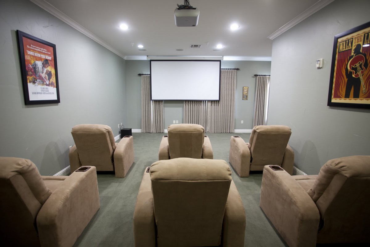 A cozy home theater setup with a projector and comfortable recliner chairs.