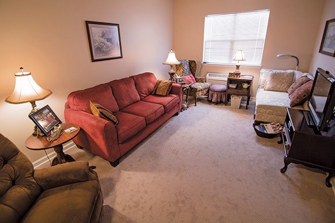A cozy living room with a red sofa and warm lighting.