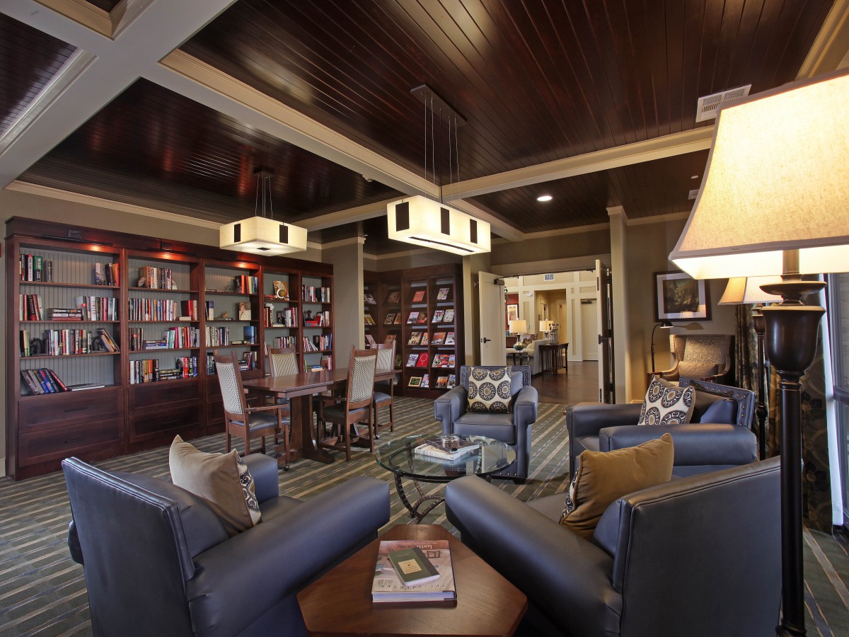 A cozy library space with comfortable seating and a rich wooden interior.
