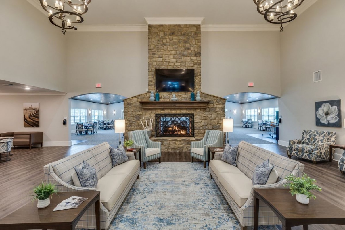 A cozy living room with a stone fireplace and comfortable seating.