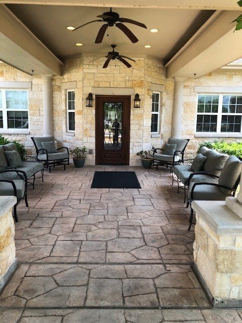 A welcoming entrance with outdoor seating and stone walls.