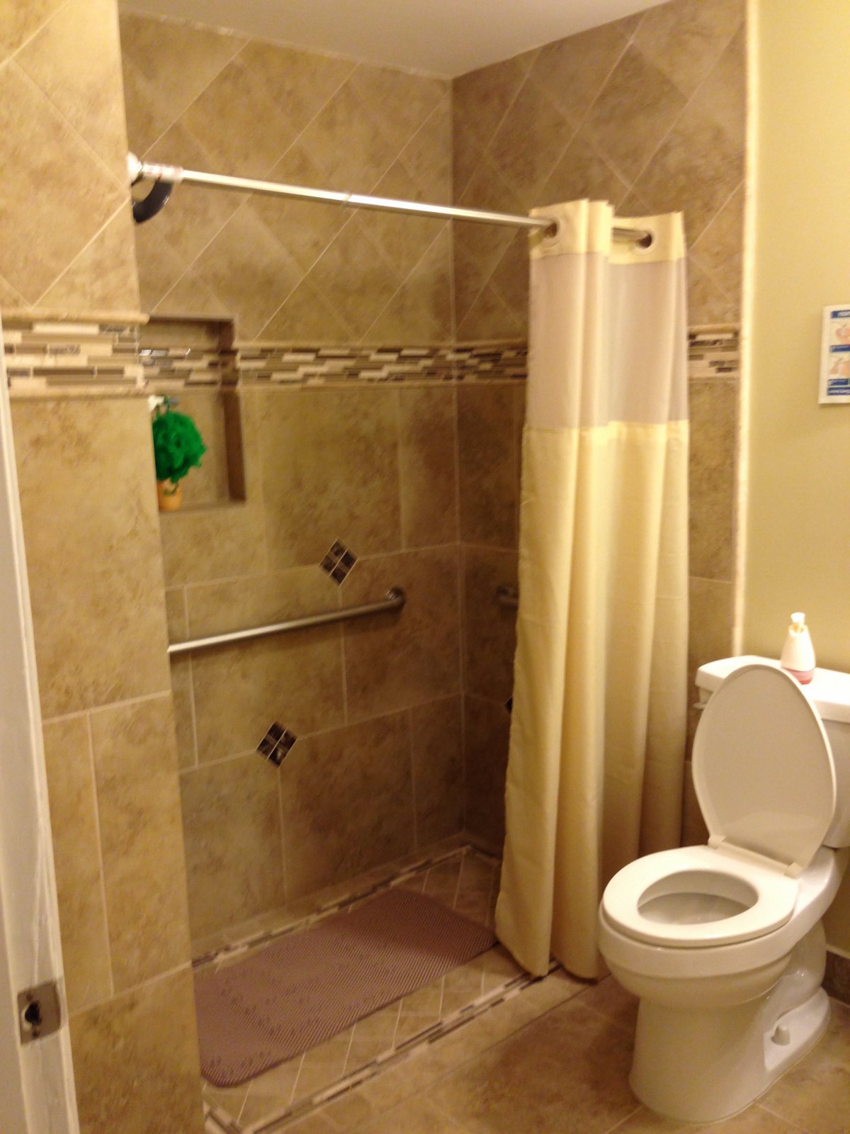 A modern bathroom with a tiled shower and white toilet.