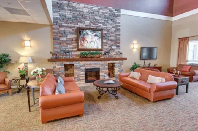A cozy living room with a brick fireplace, two sofas, and a coffee table.