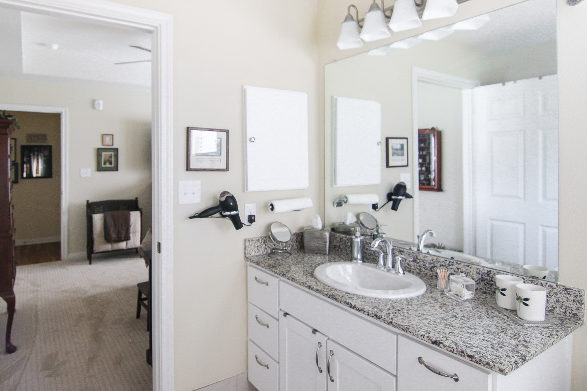 A modern bathroom with a granite countertop and stylish lighting.