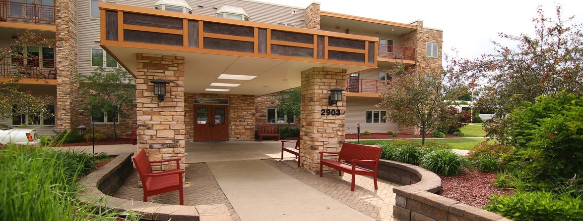 Entrance to a building with stone pillars and outdoor benches.