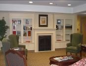 A cozy living room with a fireplace and bookshelves.