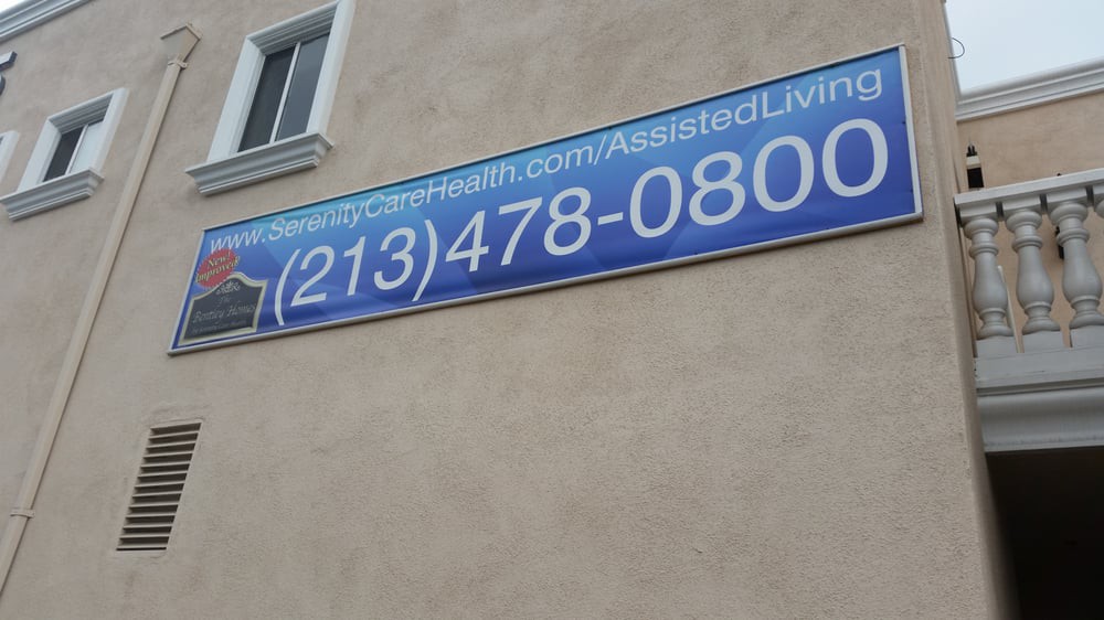A banner on a building displaying a contact phone number and website URL.