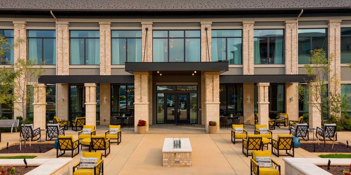 Outdoor seating area in front of a modern building entrance.