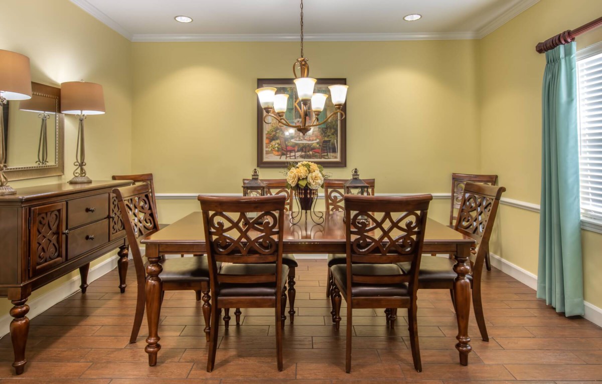 Elegant dining room with a wooden dining set and chandelier.