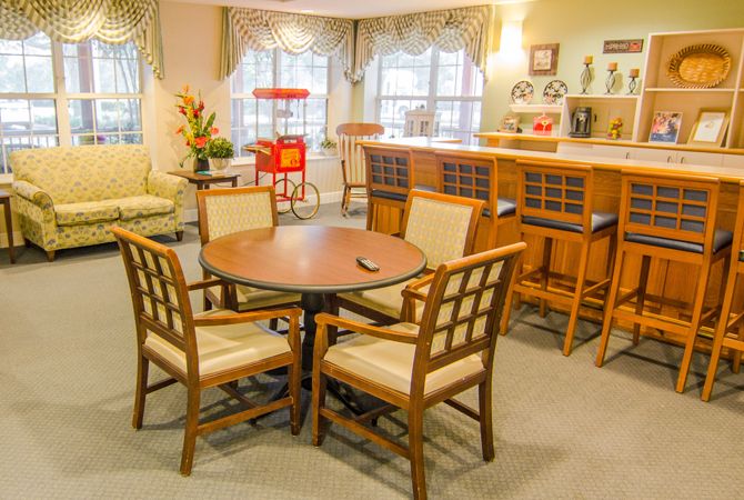 A cozy living space with a wooden table, chairs, and a bar counter.