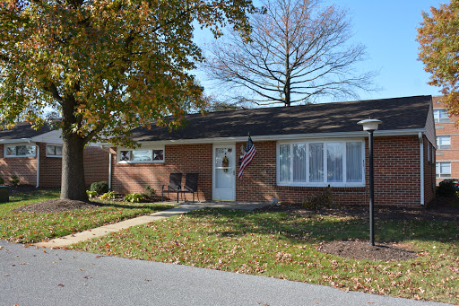 A charming single-story brick house with a well-kept front yard and an American flag displayed.