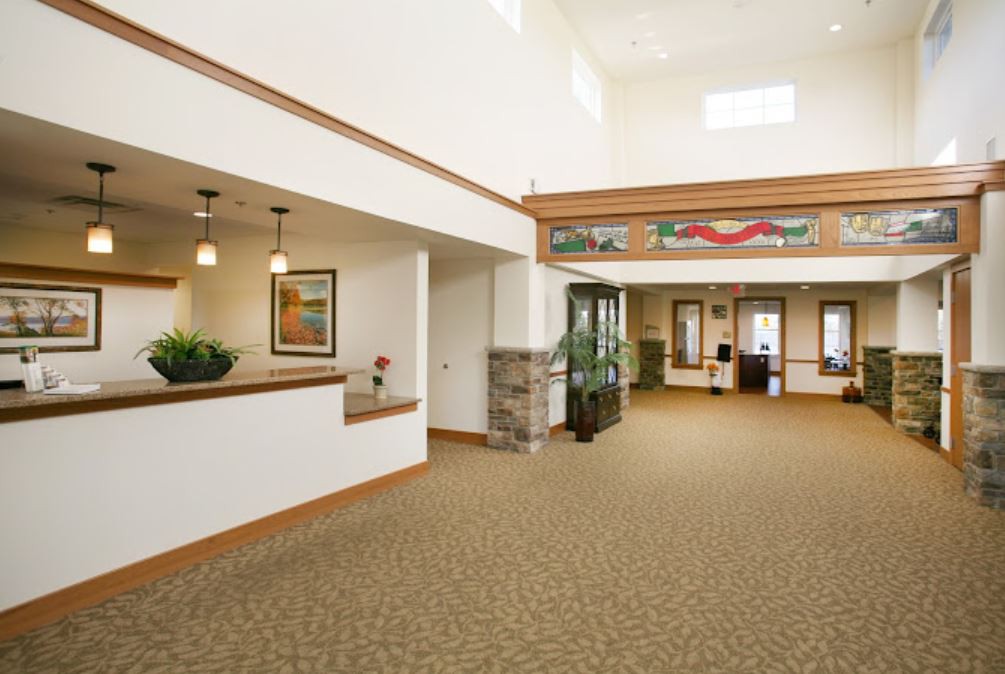 A spacious and modern office lobby with a reception desk and carpeted floor.
