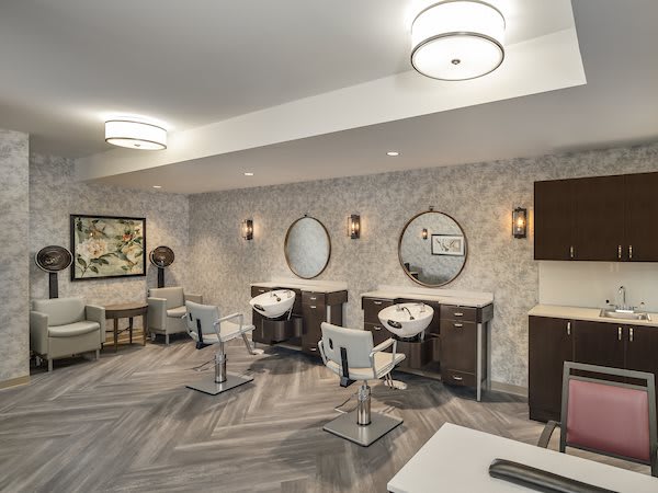 A modern and stylish hair salon interior with mirrors and chairs.