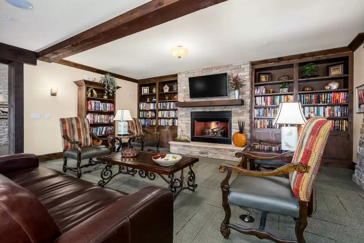 A cozy living room featuring a fireplace, built-in bookshelves, and comfortable seating.