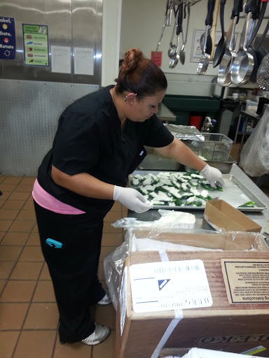 A chef meticulously preparing vegetables in a busy kitchen.
