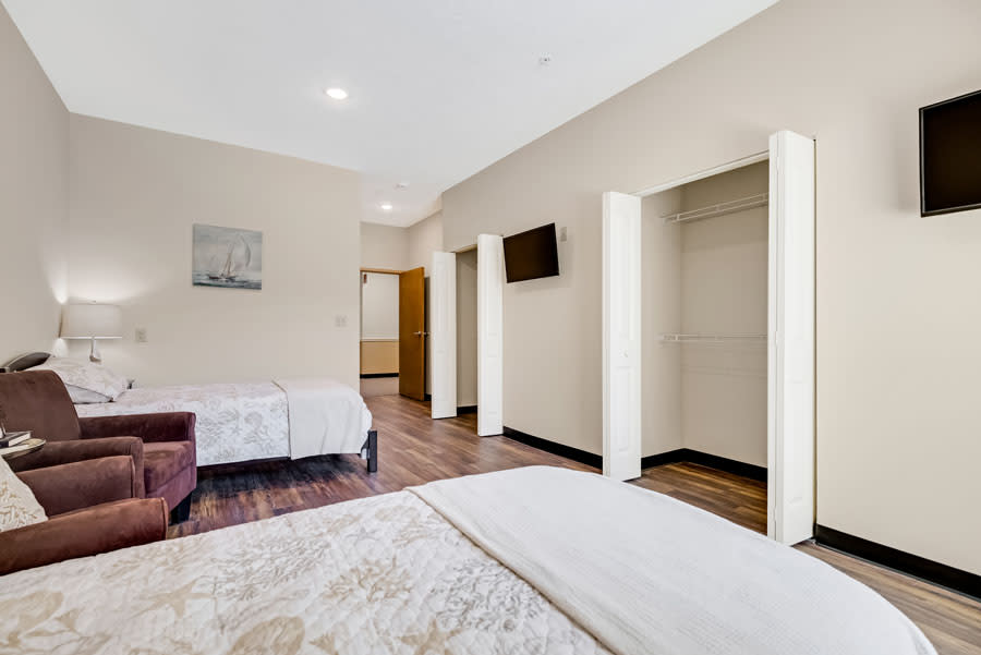 A spacious hotel room featuring modern amenities and minimalist decor.