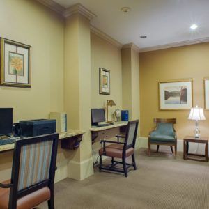 A business center with computer workstations and seating arrangements.