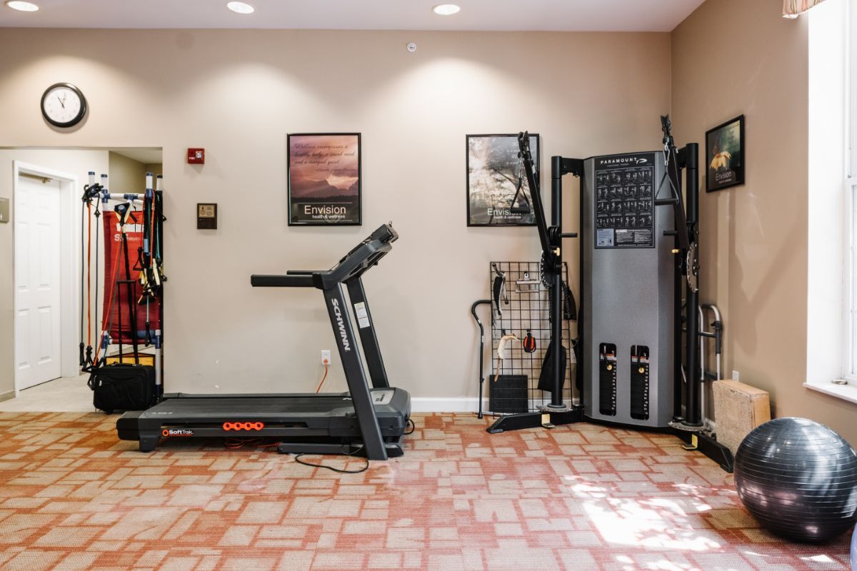 A small indoor gym with a treadmill and various exercise equipment.