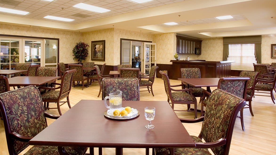 A cozy dining area with neatly arranged tables and chairs, featuring a warm ambiance.