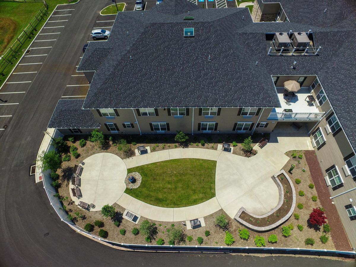Aerial view of a building surrounded by landscaped areas and parking spaces.