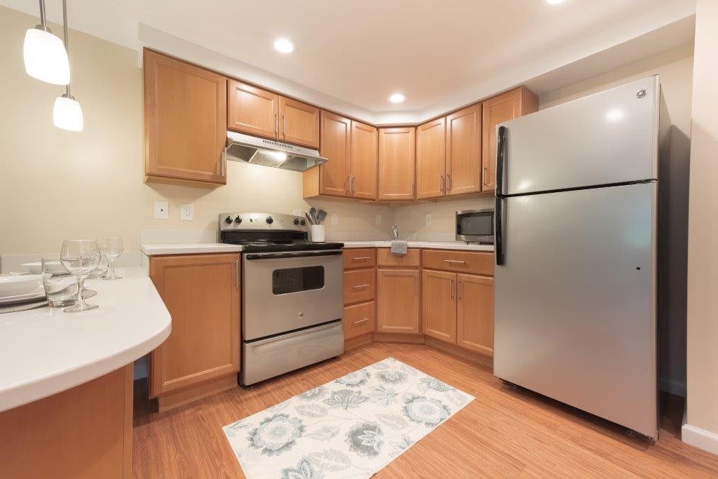 A modern kitchen with wooden cabinets and stainless steel appliances.