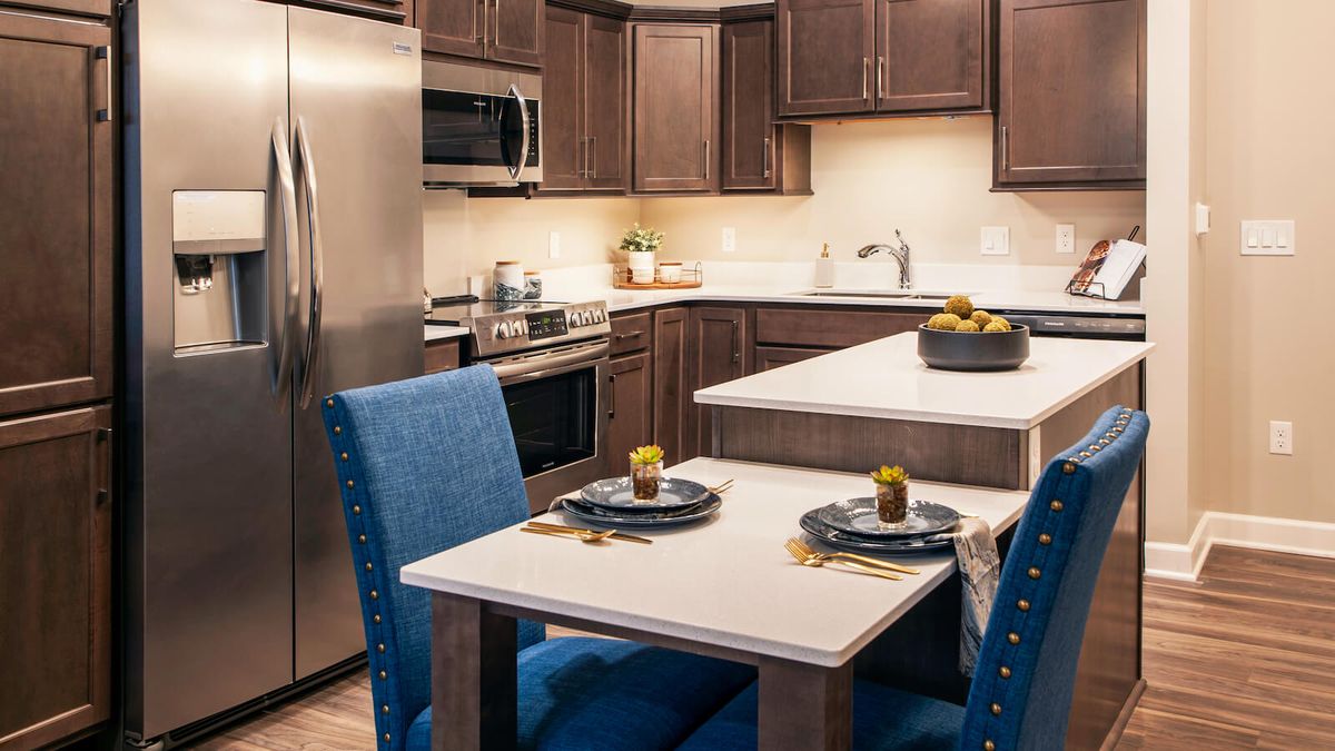 A modern kitchen with stainless steel appliances and a cozy dining area.