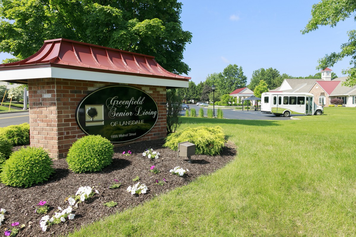 Entrance to a community with well-maintained landscaping and a scenic view of the surroundings.