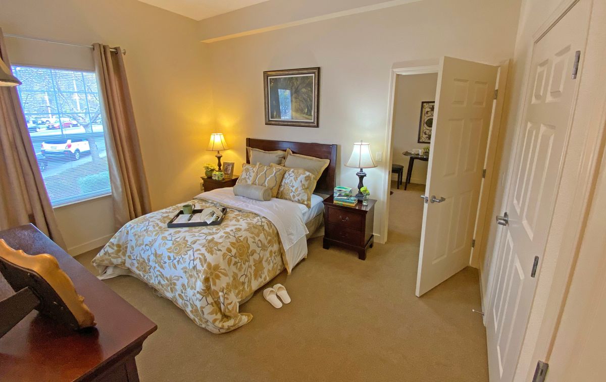 A cozy bedroom with a neatly made bed, warm lighting, and elegant decor.