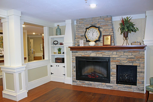 A cozy living room featuring a stylish stone fireplace and elegant decor.