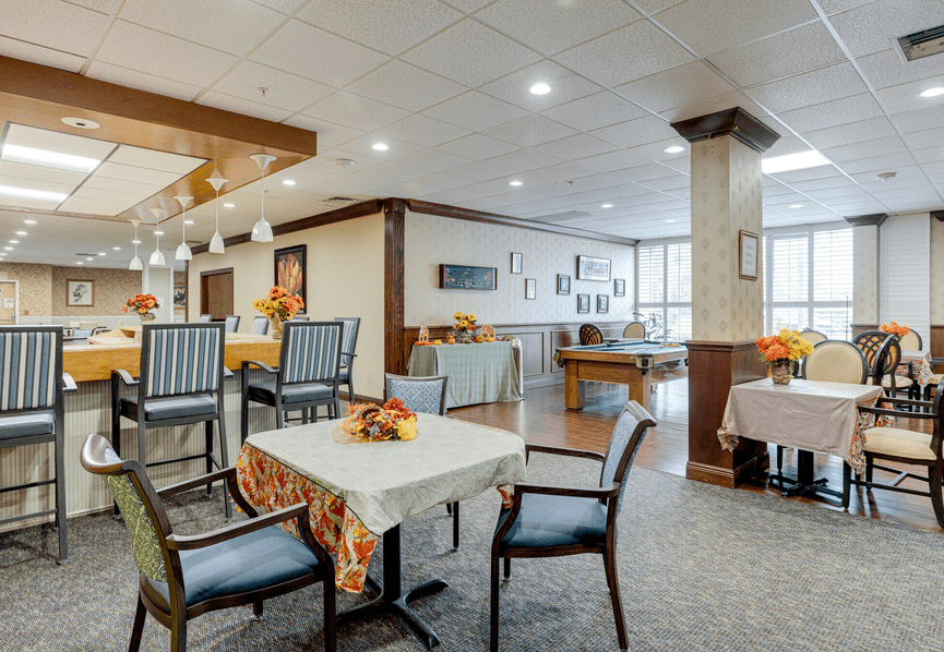 A modern and cozy dining area with neatly arranged tables and chairs, adorned with decorative centerpieces.