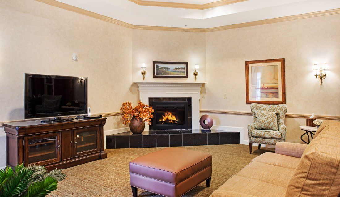 A cozy living room with a fireplace, television, and comfortable seating.