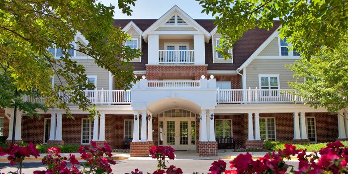 A beautiful residential building with a landscaped entrance and blooming flowers.