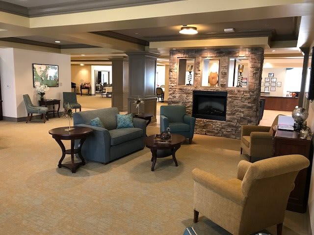 A cozy lobby area featuring comfortable seating around a stone fireplace.