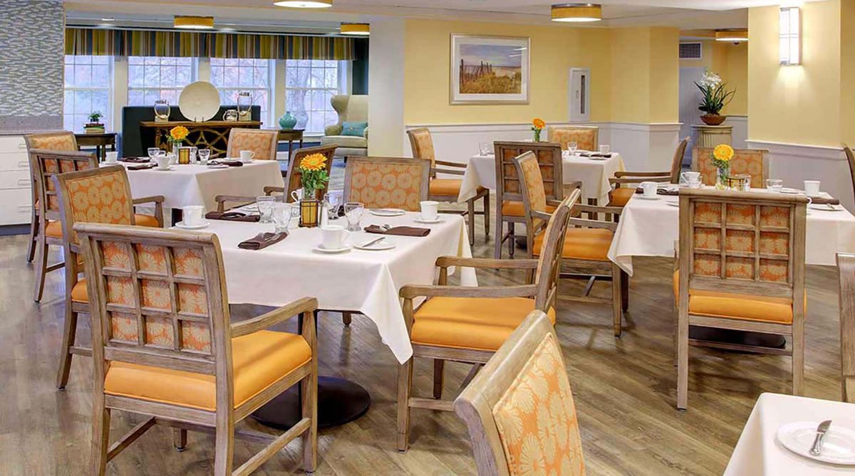 A cozy restaurant dining area featuring neatly arranged tables and chairs with elegant table settings.