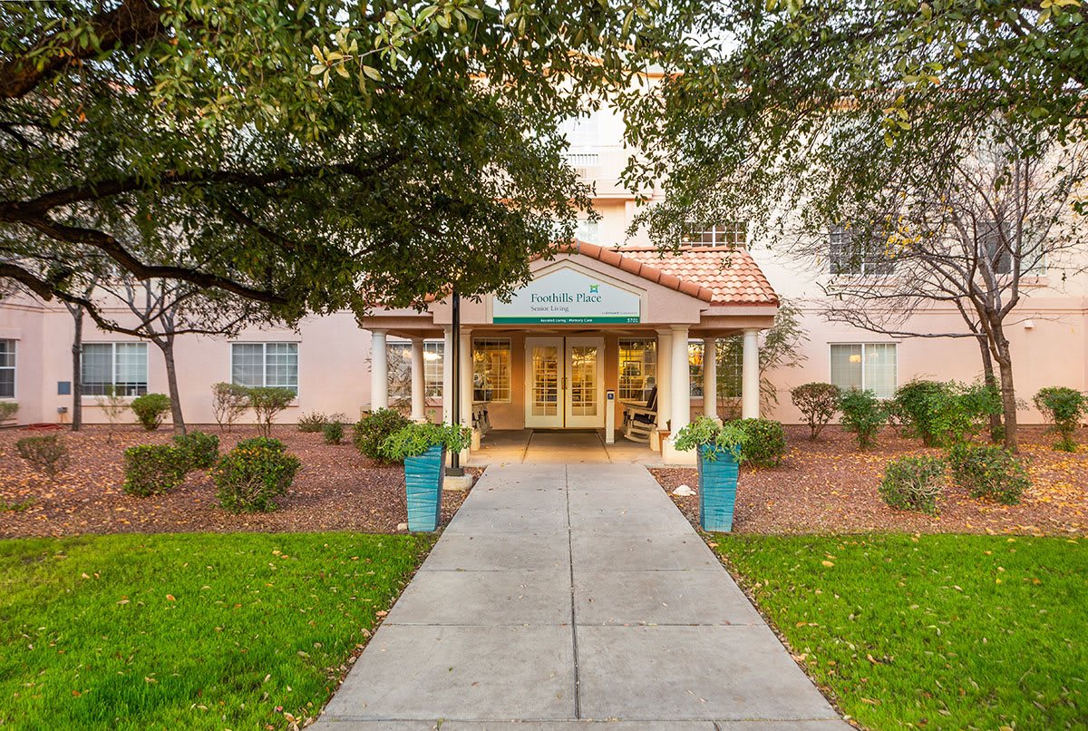 The front entrance of a hotel with a landscaped pathway.
