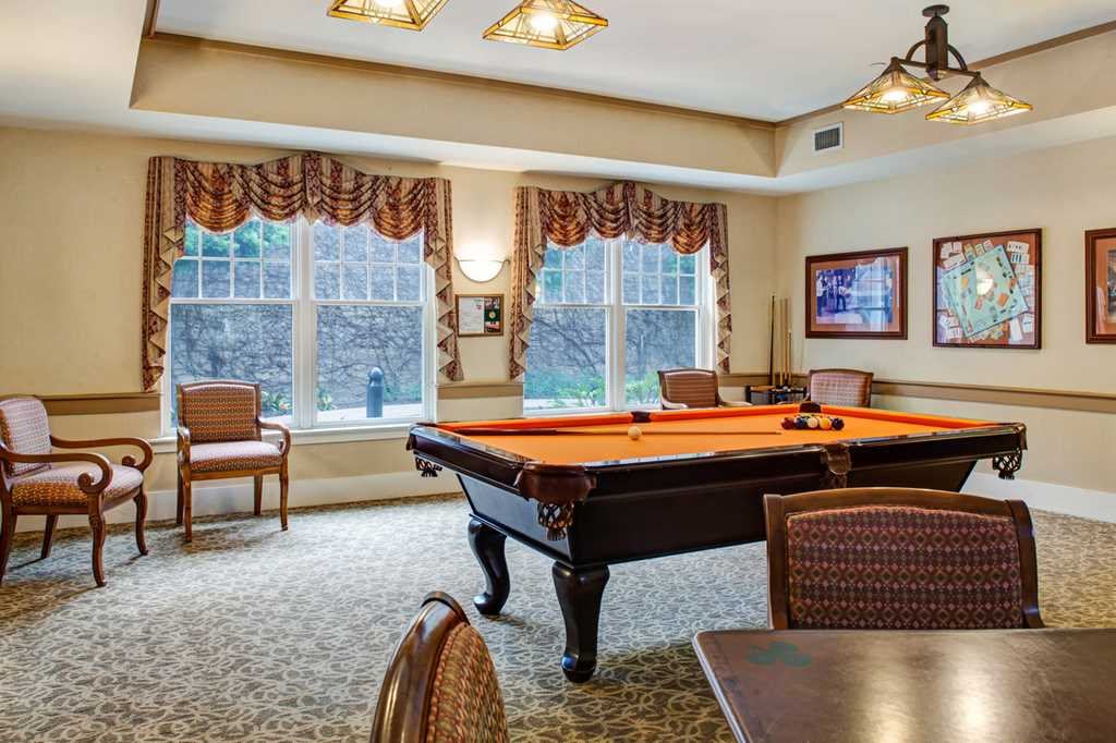 A cozy billiard room featuring a pool table and elegant furnishings.
