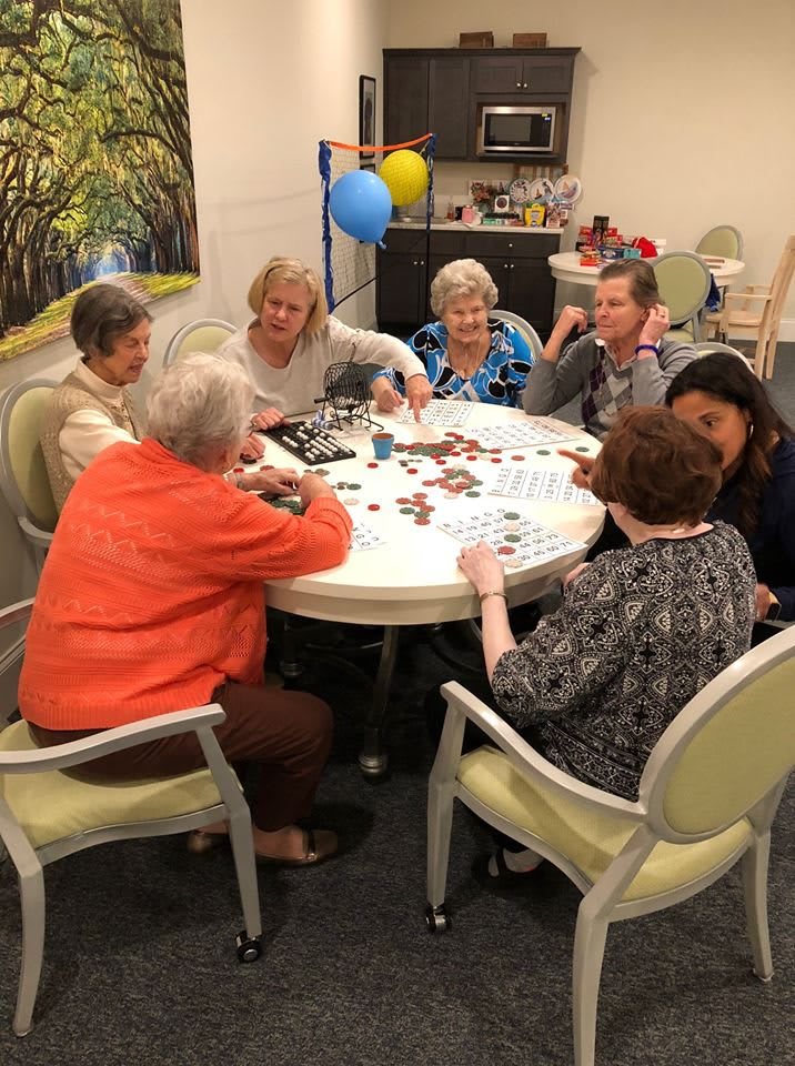 A group of seniors enjoying a card game together indoors.