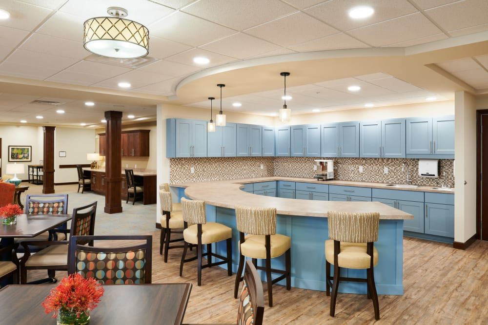 A modern kitchen with blue cabinets, bar seating, and warm lighting.