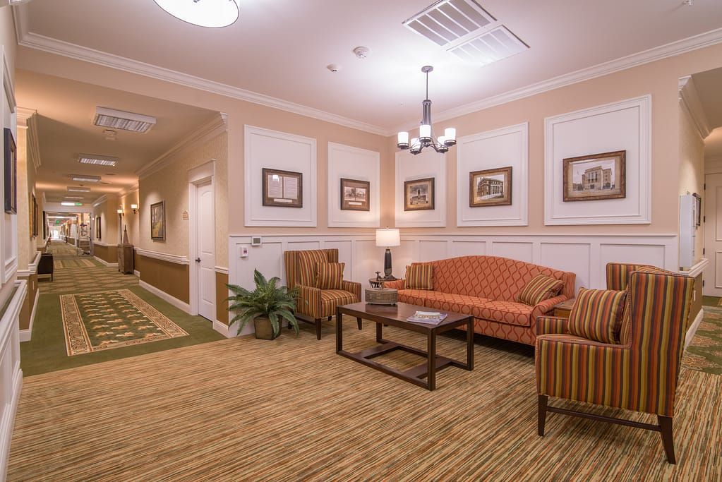 A cozy lobby area with a sofa, armchairs, and decorative artwork.