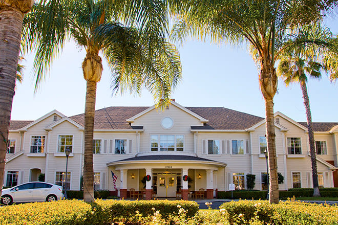 A large building with palm trees and a well-maintained entrance on a sunny day.