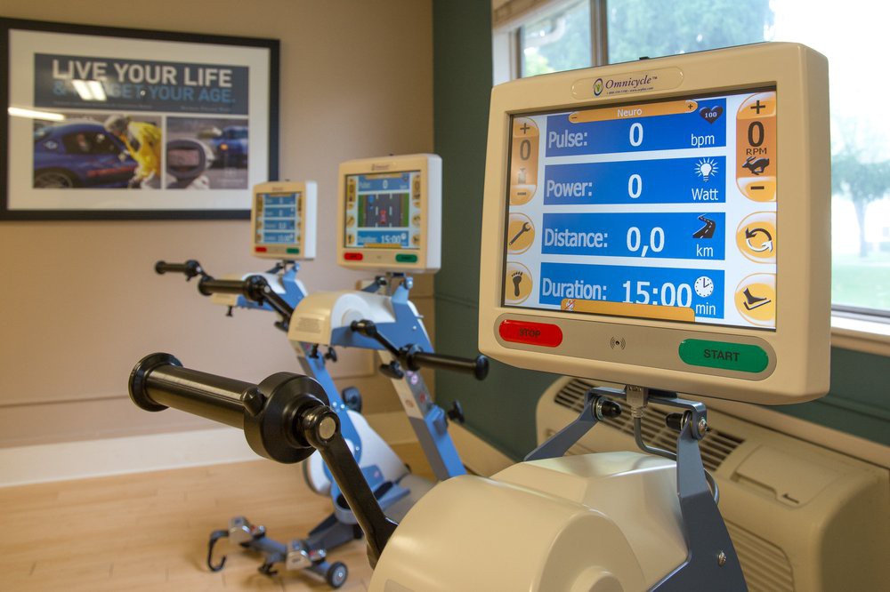 Indoor cycling equipment with digital monitors in a gym setting.