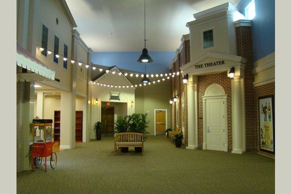 A well-lit interior of a shopping area with storefronts and decorative lighting.