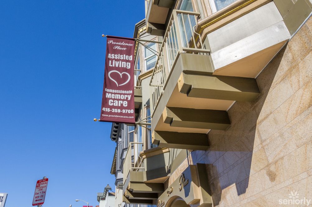 A city building with a banner advertising a senior living community and cafe.