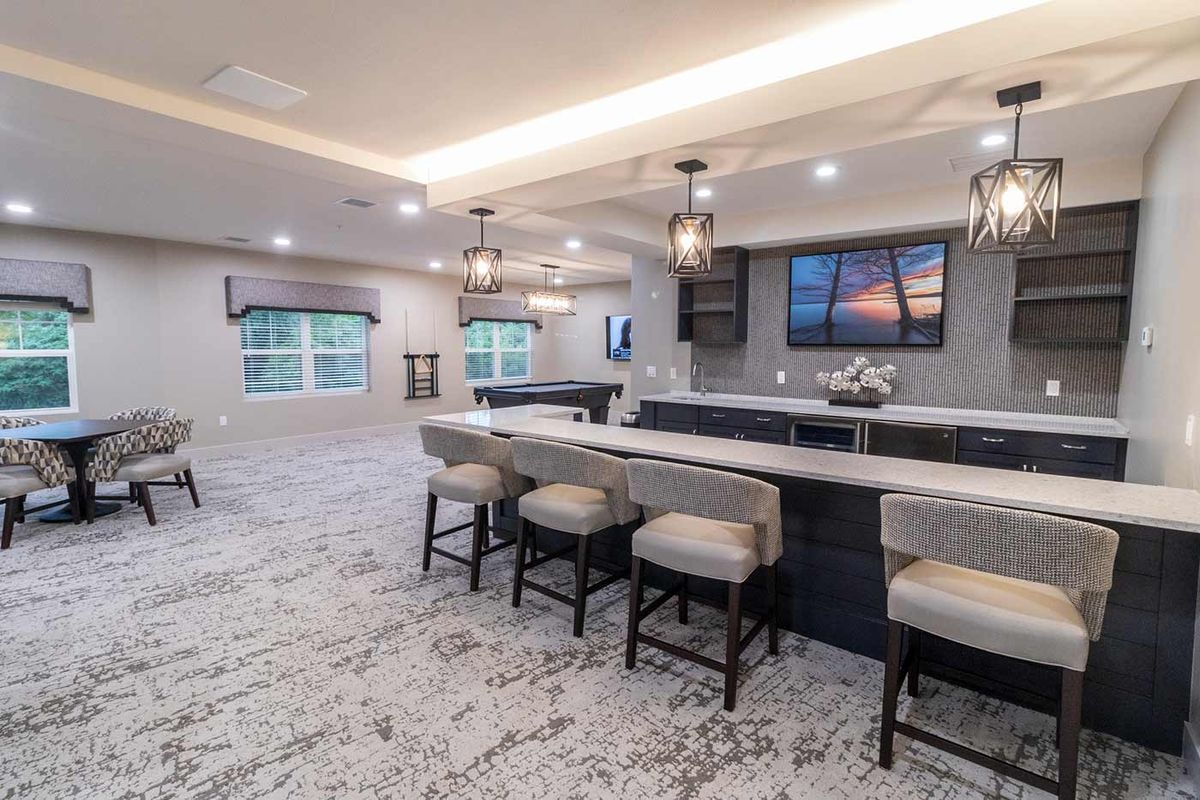 Modern and spacious kitchen with a large countertop, bar stools, and elegant lighting.