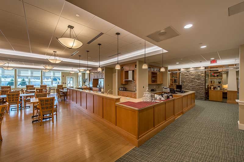 A modern kitchen and dining area with wooden furnishings and pendant lighting.